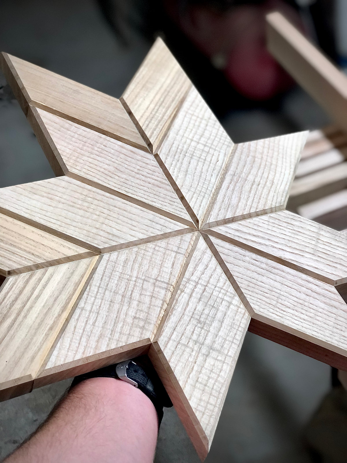 Ręczne docinanie i pasowanie drewnianych elementów geometrycznej mozaiki z litego jesionu